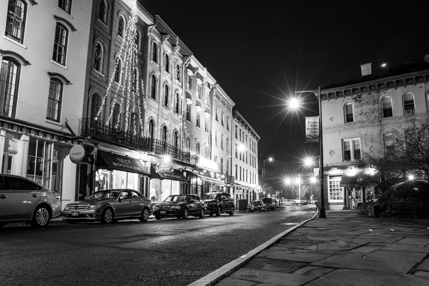 A black and white photo of West Strand Street at night.
