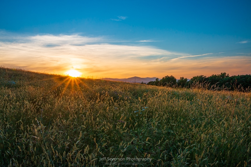 A photo during golden hour at Million Dollar View at Mohonk Preserve as the sun sets behind the Catskill Mountains.