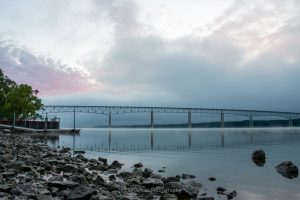 A photo of a sunrise over the Hudson River at Charles Rider Park that included a hint of color in the sky and a little mist on the river.