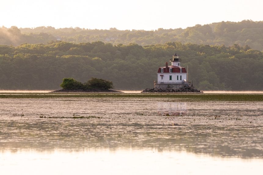 A photo of the Esopus Lighthouse on a lightly mist covered Hudson River during the golden hour of sunrise.