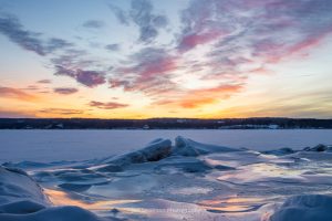 A photo of sunrise breaking over a frozen Hudson River on a February morning.