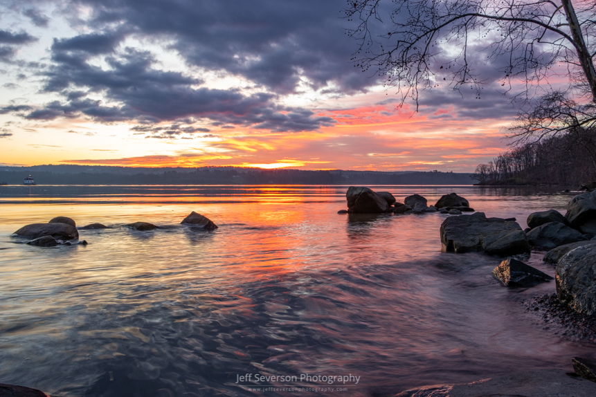 Sunrise over the Hudson River on the second morning of 2023 as waves roll in along the shore of Lighthouse Park after a ship passes.