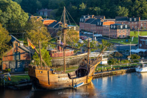 A photo of the tall ship Nao Trinidad, a replica of the16th-Century ship captained by explorer Ferdinand Magellan, at port on the Rondout Creek in Kingston during the golden hour of sunrise.