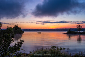 A red-orange sunrise with purple clouds over the Hudson River from the shores of Rotary Park on the last morning of Summer 2023.