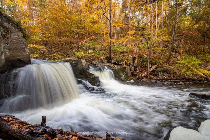 A photo of Middle Falls on Black Creek, after a rainy October, surrounded by fall foliage on an autumn morning.
