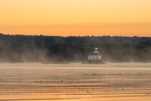 The minutes before sunrise on September morning at the Esopus Lighthouse has fog drifts over the Hudson River.