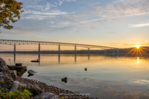 The Kingston-Rhinecliff Bridge captured from the shore of Charles Rider Park as the sun crests the horizon on a September morning.