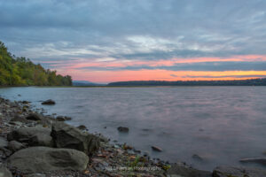 A photo looking north up the Hudson River during sunrise on a September morning from along the shoreline of Lighthouse Park.