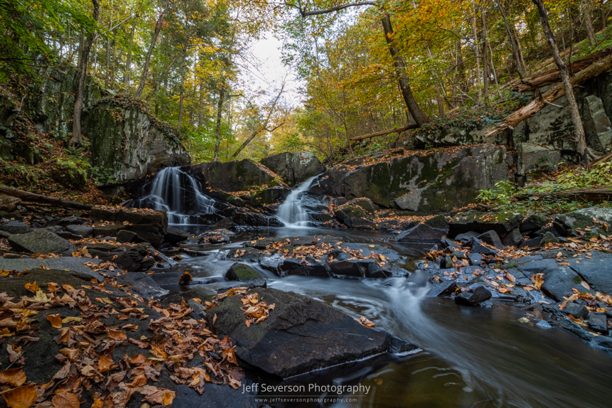 A long exposure photo of Black Creek and Middle Falls surrounded by fall foliage in early in October in Highland, NY.