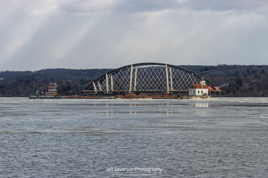 A section of the Portal North Bridge passing by the Esopus Lighthouse as it's escorted down the Hudson River to the Hackensack River in New Jersey.